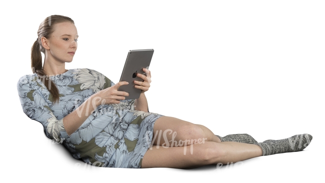 woman lying on the couch and looking at her ipad