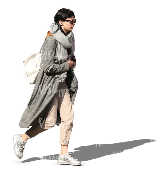 woman in a grey overcoat walking on a sunny day