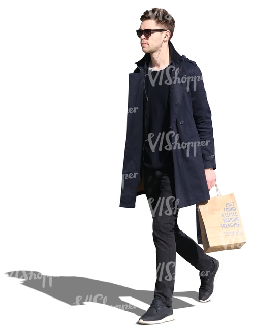 man wearing a black jacket walking with a shopping bag