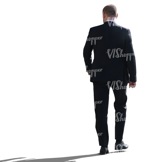 backlit businessman walking seen from behind