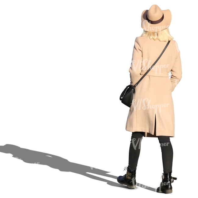 woman wearing a beige coat and hat walking