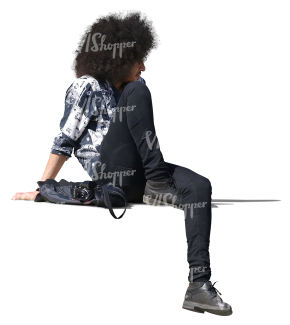 man with curly hair sitting on a balustrade