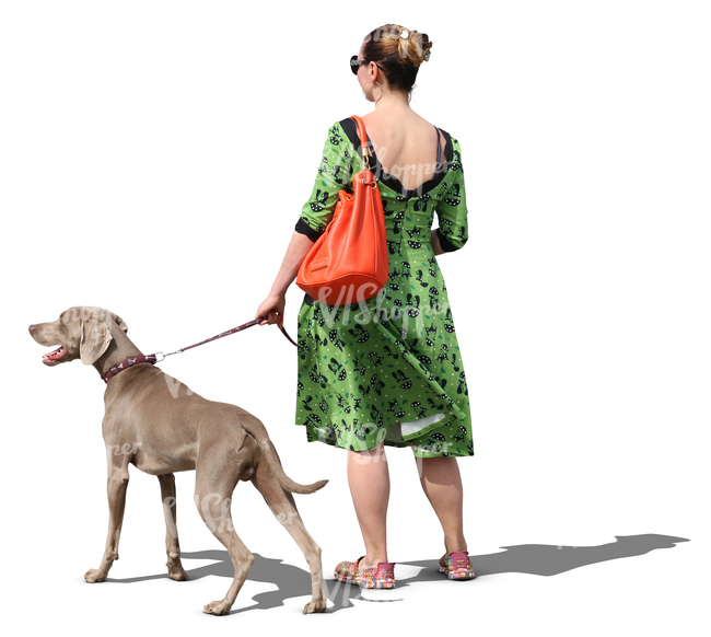 woman in a green dress walking a dog