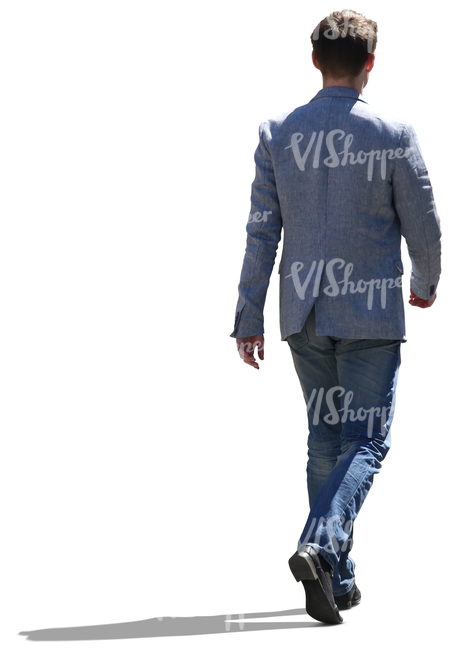 backlit man wearing jacket and jeans walking on the street