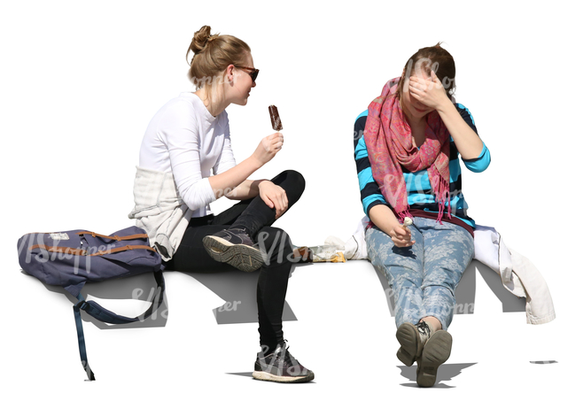 two young women sitting and eating ice cream