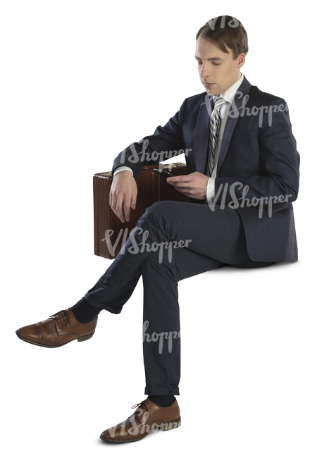 businessman with briefcase sitting and looking at his phone