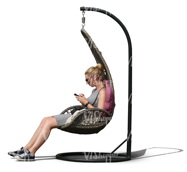 woman sitting in a hanging chair and looking at her phone