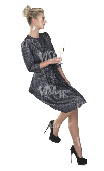 woman in cocktail gown sitting and sipping champagne