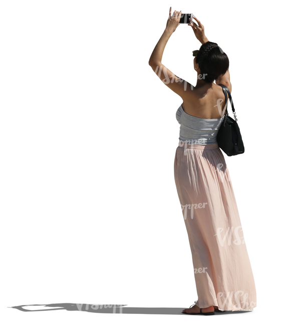 woman in a long skirt taking a picture with her phone