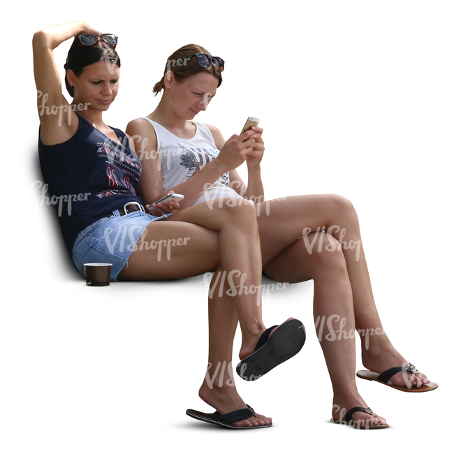 two young women sitting and looking at their phone