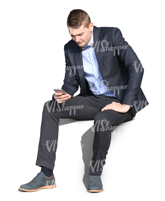 young man wearing a suit sitting and browsing his phone