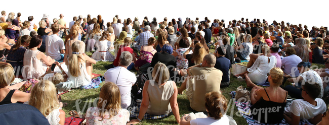 big group of people sitting on a grass on an outdoor event