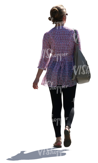 backlit woman walking on the street