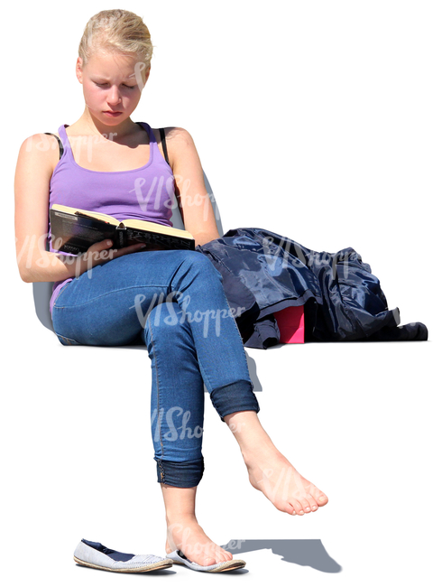 teenage girl sitting outside and reading a book