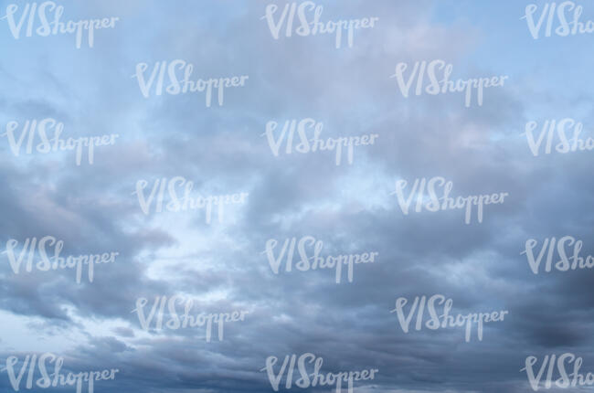 light blue sky with many grey clouds