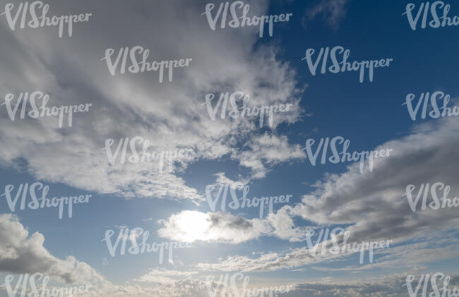 daytime sky with sun behind a small cloud