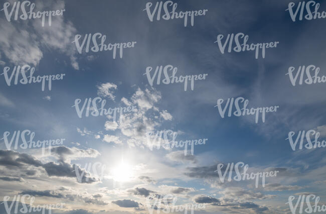 afternoon sky with sun and small clouds