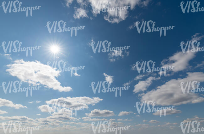 daytime sky with sun and small white clouds