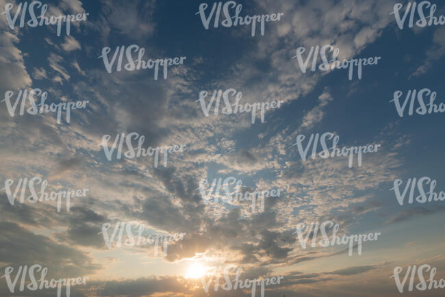 sunset with sun shining between some thin clouds