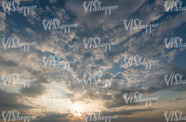 sunset with sun behind small clouds