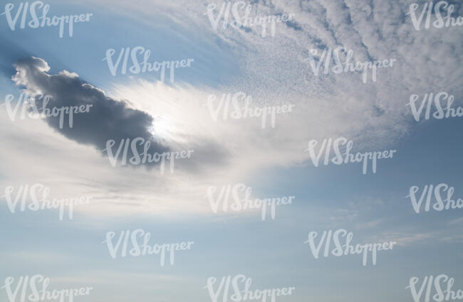 pale blue daytime sky with sun behind a small cloud
