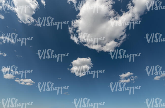 deep blue daytime sky with small white clouds