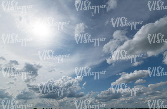 daytime sky with sun and white clouds
