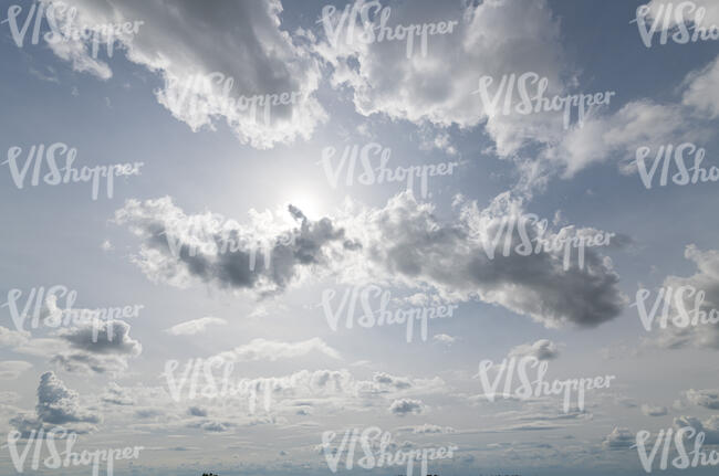 pale blue sky with sun peeking from behind a cloud