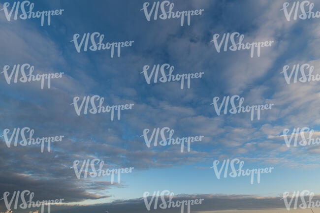 deep blue sky with grey clouds