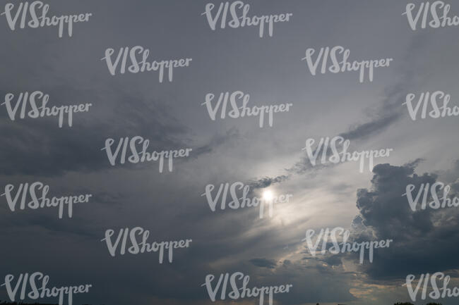grey sky with sun between the clouds