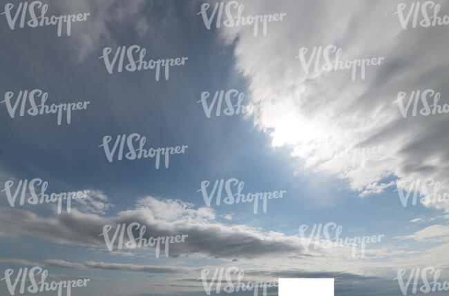 daytime sky with sun behind the white clouds