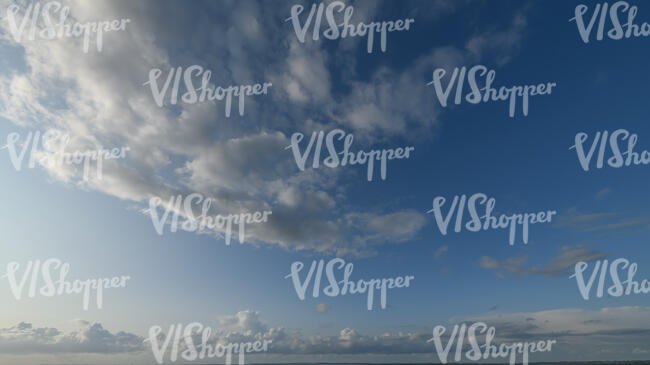 pale blue sky with cumulus clouds