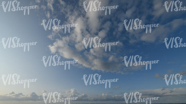 pale blue sky with cumulus clouds