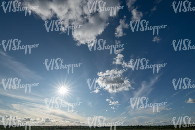 deep blue sky with some clouds and sun shining