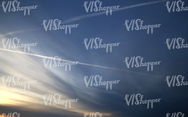 deep blue evening sky with contrails